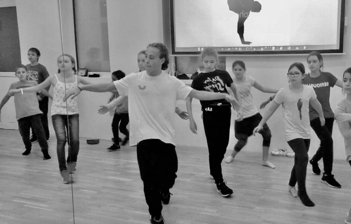 Hip-Hop-Gruppe im Training vor der Videowall, Schwarz-Weiß-Aufnahme