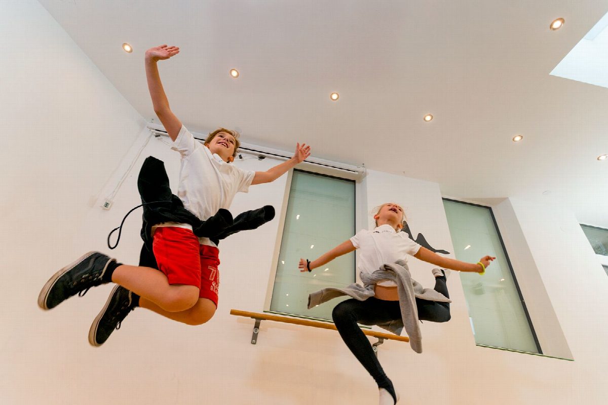 Zwei Kinder springen gleichzeitig hoch in die Luft im Studio