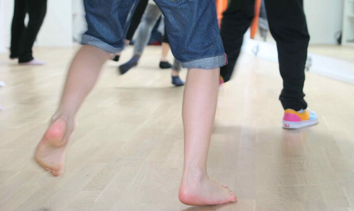 Nahaufnahme barfüßiger Kinderfüße auf dem Tanzparkett